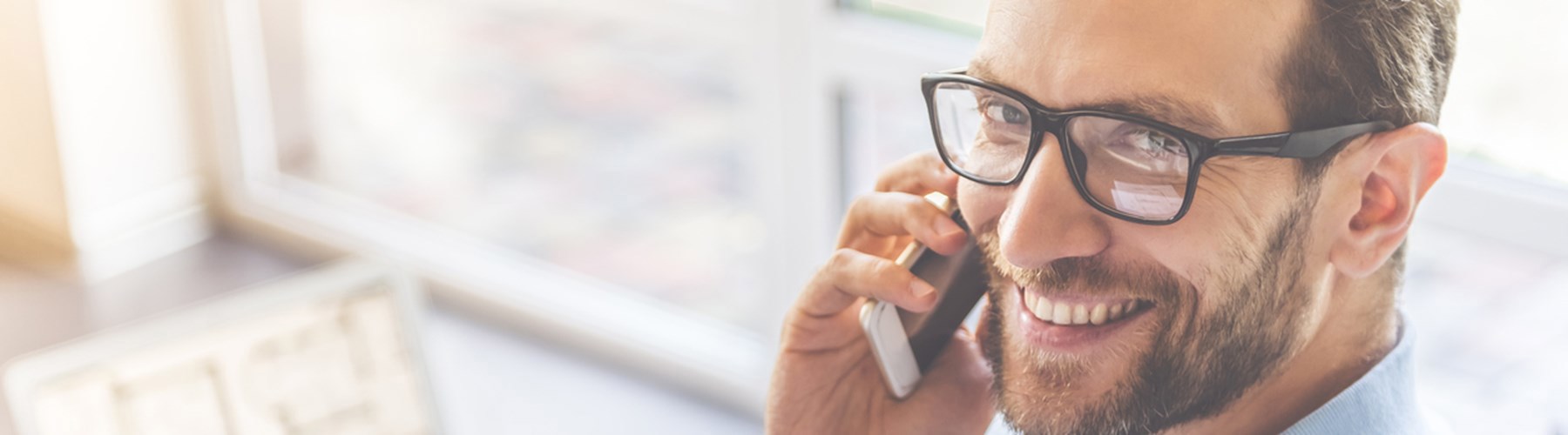A man smiling while on the phone